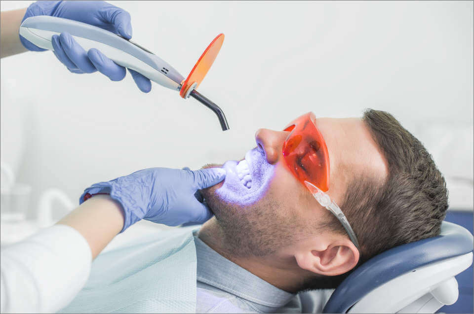 dentist Charleston, SC looking at patients' teeth