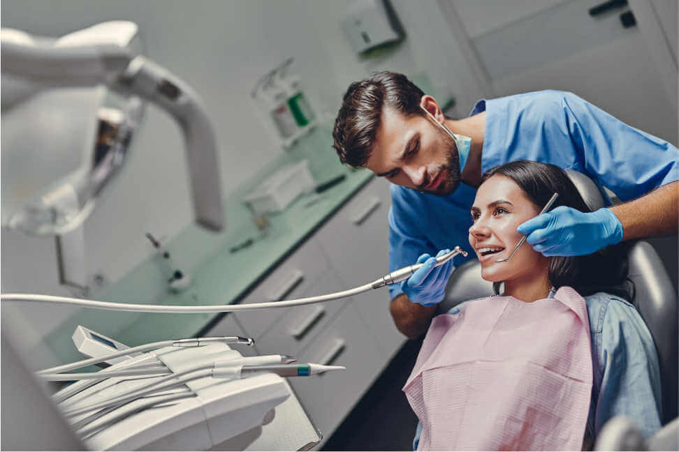 dentist in Charleston, SC cleaning patients' teeth